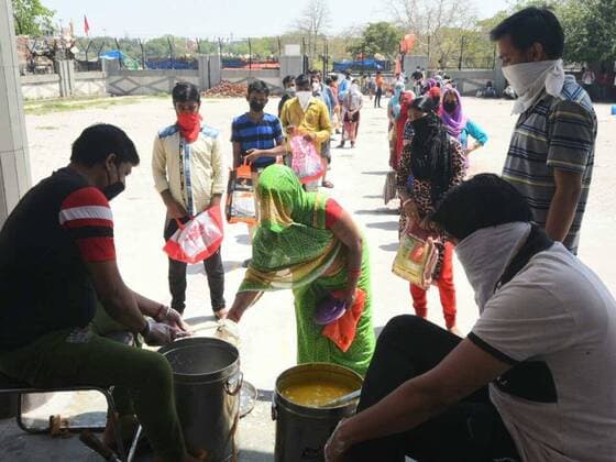 NEW DELHI, INDIA - APRIL 6: Meals are handed out at a food distribution by the Delhi Government at a Basti Vikas Kendra, on day thirteen of the 21-day nationwide lockdown to check the spread of coronavirus at Gandhi Nagar on April 6, 2020 in New Delhi, India. (Photo by Sonu Mehta Hindustan Times) Government And NGOs Provide Food To Homeless And Poor Amid Lockdown To Prevent Covid-19