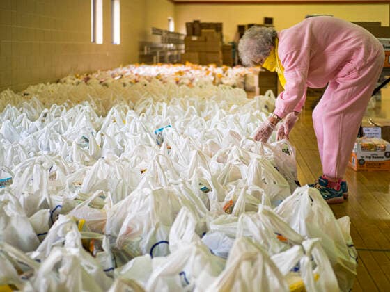 April 6, 2020, Des Moines, Iowa, USA: Volunteer MARIA CUNNINGHAM sorts bags of food before a drive-thru emergency food distribution event at First DSM Church. Well over 100,000 Iowans filed first time claims for unemployment in the last three weeks, more than applied during the peak of the Great Recession of 2008. Local food banks have seen an equal spike in people seeking nutritional assistance, and First DSM Church has increased their food pantry from one day weekly to three days per week. Hundreds of people lined up Monday to get a box of food and one roll of toilet paper. Des Moines USA - ZUMAk94_ 20200406_zaf_k94_006 Copyright: xJackxKurtzx