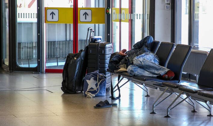 Coronavirus in Berlin Berlin, 06 04 2020, Tegel Airport Because of the measures taken to contain the coronavirus, the benches in the waiting area of Terminal A, which are always overcrowded, remain unusually deserted. A man sleeps next to his suitcases Berlin Berlin Germany Tegel Airport