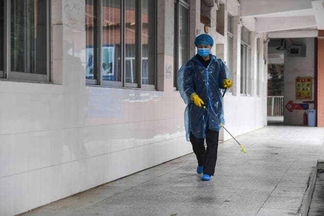 (200407) -- NANNING, April 7, 2020 -- A member of staff disinfects the hallway of a teaching building at the No. 3 High School in Nanning, south China s Guangxi Zhuang Autonomous Region, April 7, 2020. Students in the final year of senior and junior high schools returned to school on Tuesday in Guangxi. ) CHINA-GUANGXI-NANNING-SENIOR HIGH SCHOOL STUDENTS-RETURNING TO SCHOOL (CN) CaoxYiming 
