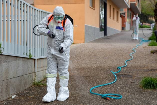 April 7, 2020, Girona, Spain: A civil protection agent dressed in a protective suit sprays disinfectants at the Centre Residencial Gerunda..During the Covid-19 crisis, the civil protection agents of Gerona carry out disinfection tasks in residential areas. Girona Spain - ZUMAs197 20200407_zaa_s197_023 Copyright: xDavidxApariciox