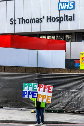 April 7, 2020, London, England, United Kingdom: A woman holding up signs (PPE-Personal Protection Equipment) stands outside St Thomas Hospital in central London as British Prime Minister Boris Johnson is in intensive care fighting the coronavirus in London, Tuesday, April 7, 2020. London United Kingdom - ZUMAx02_ 20200407_zaf_x02_003 Copyright: xVudixXhymshitix