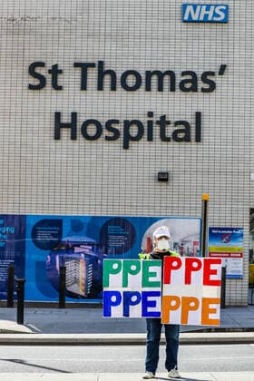 April 7, 2020, London, England, United Kingdom: A woman holding up signs (PPE-Personal Protection Equipment) stands outside St Thomas Hospital in central London as British Prime Minister Boris Johnson is in intensive care fighting the coronavirus in London, Tuesday, April 7, 2020. London United Kingdom - ZUMAx02_ 20200407_zaf_x02_008 Copyright: xVudixXhymshitix