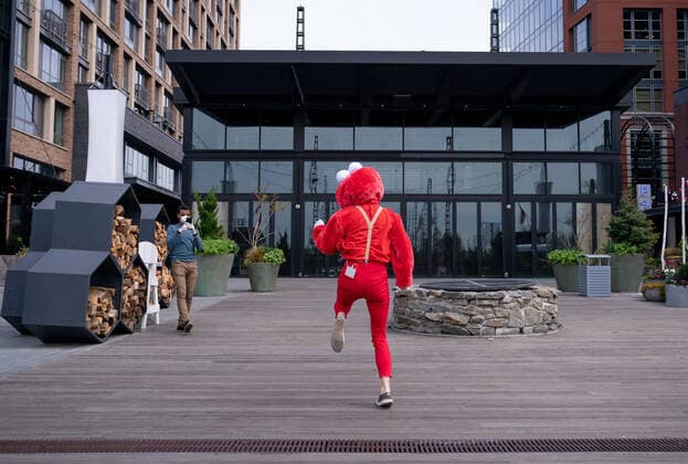A YouTube performer known as Elmo at the Wharf dances on the Wharf in Washington, D.C. during the Coronavirus pandemic and stay at home order, on Tuesday, April 7, 2020. The performer said she was attempting to bring smiles and joy to the people in the apartment buildings that overlook the area.  WAP20200407311 KEVINxDIETSCH