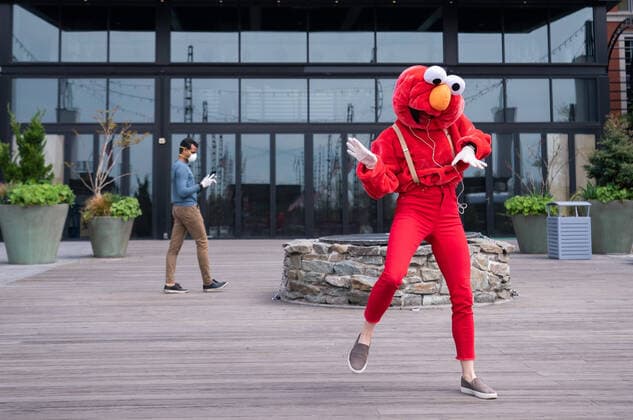 A YouTube performer known as Elmo at the Wharf dances on the Wharf in Washington, D.C. during the Coronavirus pandemic and stay at home order, on Tuesday, April 7, 2020. The performer said she was attempting to bring smiles and joy to the people in the apartment buildings that overlook the area.  WAP20200407313 KEVINxDIETSCH