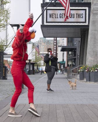 A YouTube performer known as Elmo at the Wharf dances on the Wharf in Washington, D.C. during the Coronavirus pandemic and stay at home order, on Tuesday, April 7, 2020. The performer said she was attempting to bring smiles and joy to the people in the apartment buildings that overlook the area.  WAP20200407325 KEVINxDIETSCH