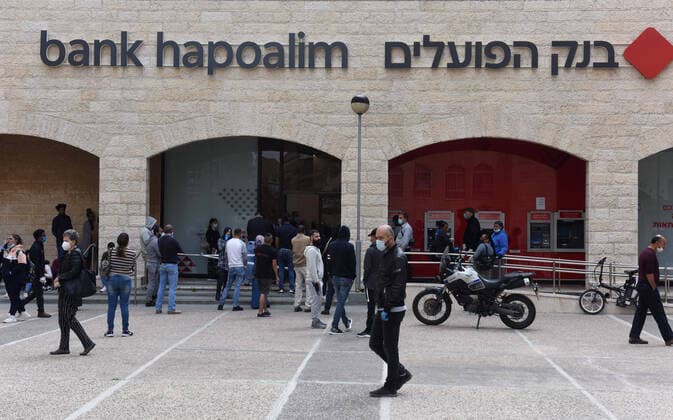 Israelis wait to enter a bank, because of coronavirus restrictions, before the Jewish holiday of Passover, on Tuesday, March 7, in Jerusalem. Israeli Prime Minister Benjamin announced severe travel restrictions and a curfew for the Passover holiday, as an effort to halt the spread of the coronavirus.  JER2020040701 DEBBIExHILL