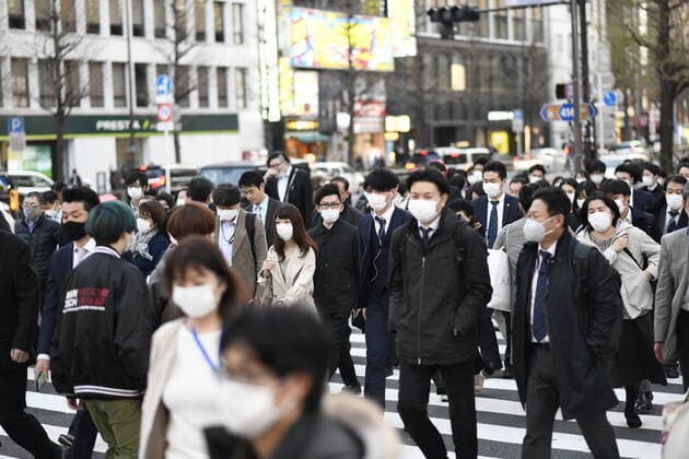 TOKYO, JAPAN - APRIL 7: Commuters wearing masks walk across the road in Shinjuku business district, Tuesday, April 7, 2020, in Tokyo. Japanese Prime Minister Shinzo Abe declared a state of emergency on Tuesday for Tokyo and six other prefectures to ramp up defenses against the spread of the coronavirus. (Photo: Richard Atrero de Guzman AFLO)  (125133449)