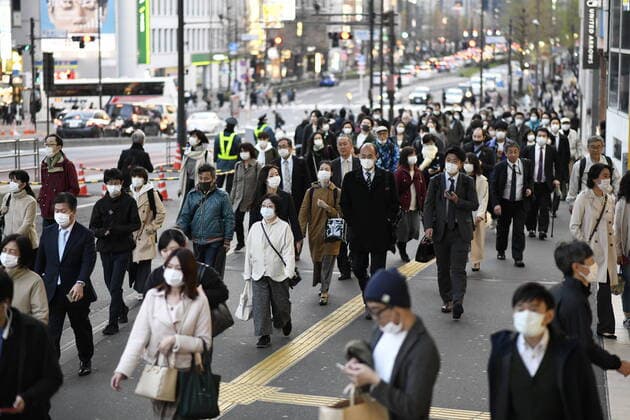 TOKYO, JAPAN - APRIL 7: Commuters wearing masks walk across the street in Shinjuku business district, Tuesday, April 7, 2020, in Tokyo. Japanese Prime Minister Shinzo Abe declared a state of emergency on Tuesday for Tokyo and six other prefectures to ramp up defenses against the spread of the coronavirus. (Photo: Richard Atrero de Guzman AFLO)  (125133503)