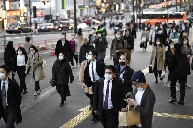 TOKYO, JAPAN - APRIL 7: Commuters wearing masks walk across the street in Shinjuku business district, Tuesday, April 7, 2020, in Tokyo. Japanese Prime Minister Shinzo Abe declared a state of emergency on Tuesday for Tokyo and six other prefectures to ramp up defenses against the spread of the coronavirus. (Photo: Richard Atrero de Guzman AFLO)  (125133505)