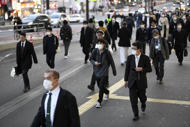 TOKYO, JAPAN - APRIL 7: Commuters wearing masks walk across the street in Shinjuku business district, Tuesday, April 7, 2020, in Tokyo. Japanese Prime Minister Shinzo Abe declared a state of emergency on Tuesday for Tokyo and six other prefectures to ramp up defenses against the spread of the coronavirus. (Photo: Richard Atrero de Guzman AFLO)  (125133506)