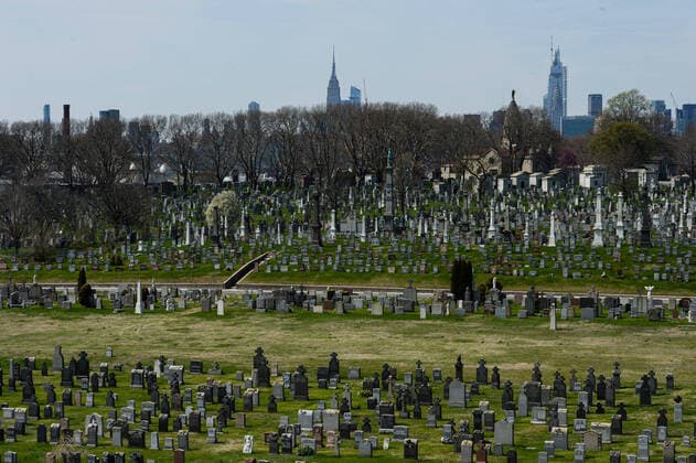 April 7, 2020, New York Queens, USA: NYC skyline behind Calvary Cemetery is a Roman Catholic cemetery. Mortuary system is overwhelmed. Morgues, hospitals, funeral homes, cemeteries and crematoria. The COVID-19 death toll in the NYC is 3,324 and 72,324 confirmed cases. 04 07 20. New York Queens Saint John Cemetery. New York Queens USA - ZUMAs252 20200407_znp_s252_040 Copyright: xMarcusxSantosx