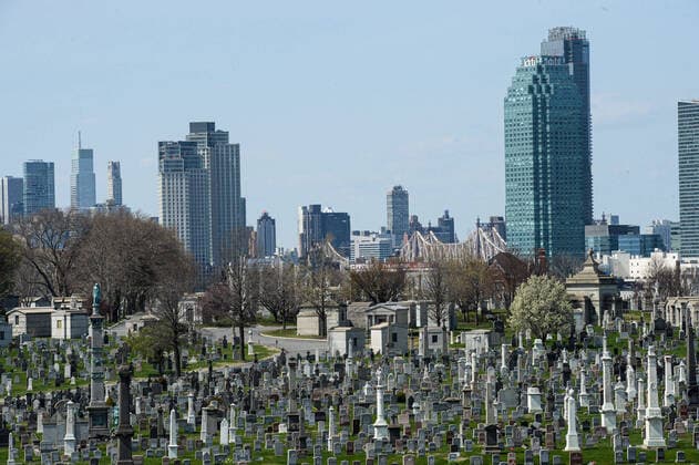 April 7, 2020, New York Queens, USA: NYC skyline behind Calvary Cemetery is a Roman Catholic cemetery. Mortuary system is overwhelmed. Morgues, hospitals, funeral homes, cemeteries and crematoria. The COVID-19 death toll in the NYC is 3,324 and 72,324 confirmed cases. 04 07 20. New York Queens Saint John Cemetery. New York Queens USA - ZUMAs252 20200407_znp_s252_047 Copyright: xMarcusxSantosx