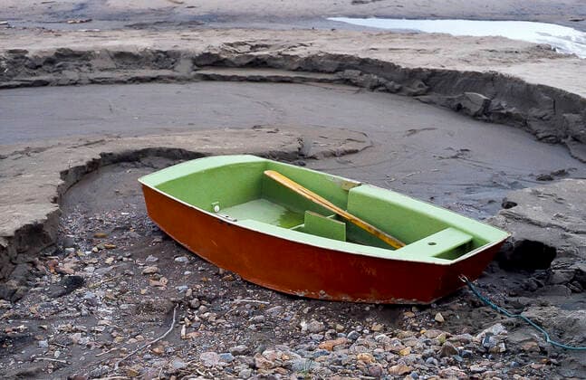 IMAGO Nature: Unsere Erde, Klimawandel, Dürren Rowboat on Land Small red green rowboat washed up on dry land  Copyright: xmellby1x 9762642
