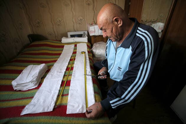 SOCHI, RUSSIA - APRIL 8, 2020: Georgy Barsegyan cutting fabric for face masks. The Barsegyans receive materials from the Sochi city hall, sew face masks and give them to volunteers and healthcare workers attending patients under quarantine. Dmitry Feoktistov TASS  TS0D4D9D