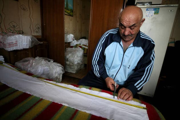 SOCHI, RUSSIA - APRIL 8, 2020: Gamlet Barsegyan cutting fabric for face masks. The Barsegyans receive materials from the Sochi city hall, sew face masks and give them to volunteers and healthcare workers attending patients under quarantine. Dmitry Feoktistov TASS  TS0D4DA2