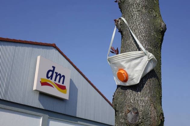 dm and mouthguard dm and mouthguard, 08 04 2020, Werder, Brandenburg, In front of a dm shop a mouthguard is hanging from a tree trunk
