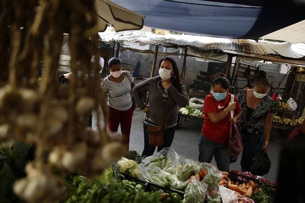 Women buy vegetables at a popular market in Atiquizaya, El Salvador, 7 April 2020 (issued 8 April 2020). The residents and visitors of the western town of Atiquizaya must pass under a sanitary tunnel in which they are completely sprayed with a disinfecting liquid, a peculiar measure adopted by the authorities of that city to try to keep COVID-19 out of that Salvadoran population. Salvadoran town tries to surround COVID-19 with a sanitary tunnel !ACHTUNG: NUR REDAKTIONELLE NUTZUNG!  Copyright: xRodrigoxSurax AME1176 20200408-637219773285088996