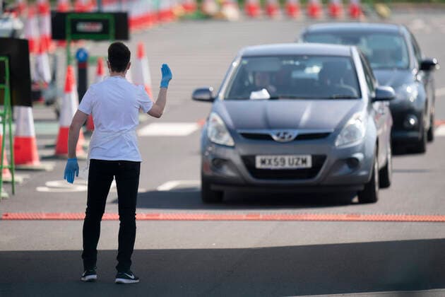 (200408) -- MANCHESTER (BRITAIN), April 8, 2020 -- A worker directs drivers in their cars at a drive-through COVID-19 testing facility in Manchester, Britain, on April 8, 2020. As of Wednesday morning, the number of confirmed COVID-19 cases in Britain hit 60,733, up 5,492 in the past 24 hours, said the Department of Health and Social Care. (Photo by Xinhua) BRITAIN-MANCHESTER-COVID-19-DRIVE THROUGH TEST JonxSuper