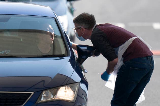 (200408) -- MANCHESTER (BRITAIN), April 8, 2020 -- A tester takes a sample from a person in a car at a drive-through COVID-19 testing facility in Manchester, Britain, on April 8, 2020. As of Wednesday morning, the number of confirmed COVID-19 cases in Britain hit 60,733, up 5,492 in the past 24 hours, said the Department of Health and Social Care. (Photo by Xinhua) BRITAIN-MANCHESTER-COVID-19-DRIVE THROUGH TEST JonxSuper