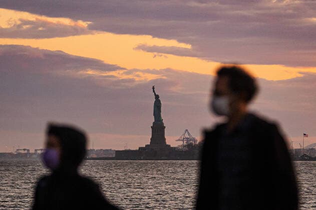 200408 People wear protective face masks when walking in Wagner Park in front of The Statue of Liberty as the coronavirus, COVID 19, outbreak continues on April 8, 2020 in New York, NY, USA Across the city businesses, schools and places of work have been shutting down, leading to empty streets and quiet neighborhoods Photo Joel Marklund BILDBYRAN kod JM 88132 bbeng coronavirus covid 19 virus corona sjukdom  Copyright: JOELxMARKLUND 47124520st