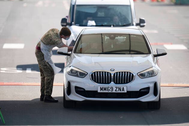 (200409) -- MANCHESTER, April 9, 2020 (Xinhua) -- A soldier takes samples from a driver at a drive-thru COVID-19 testing site in Manchester, Britain, on April 8, 2020. (Photo by Jon Super Xinhua) BRITAIN-MANCHESTER-COVID-19-TESTING SITE 