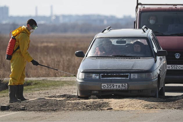 RYAZAN REGION, RUSSIA - APRIL 9, 2020: Disinfecting a vehicle at a checkpoint at an entrance to the village of Zaokskoye where several cases of the COVID-19 coronavirus infection were registered. The villages of Zaokskoye and Korostovo, Ryazan Region, have been put into lockdown from April 8 till April 22, 2020, to prevent the spread of the virus. Despite the novel coronavirus pandemic residents of the villages had been going to Moscow to sell dairy products, which, according to the local residents, led to the outbreak in the villages. Alexander Ryumin TASS  TS0D5085