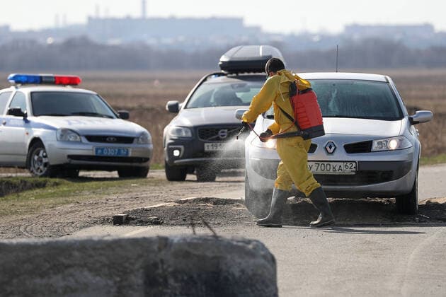 RYAZAN REGION, RUSSIA - APRIL 9, 2020: Disinfecting a vehicle at a checkpoint at an entrance to the village of Zaokskoye where several cases of the COVID-19 coronavirus infection were registered. The villages of Zaokskoye and Korostovo, Ryazan Region, have been put into lockdown from April 8 till April 22, 2020, to prevent the spread of the virus. Despite the novel coronavirus pandemic residents of the villages had been going to Moscow to sell dairy products, which, according to the local residents, led to the outbreak in the villages. Alexander Ryumin TASS  TS0D508B