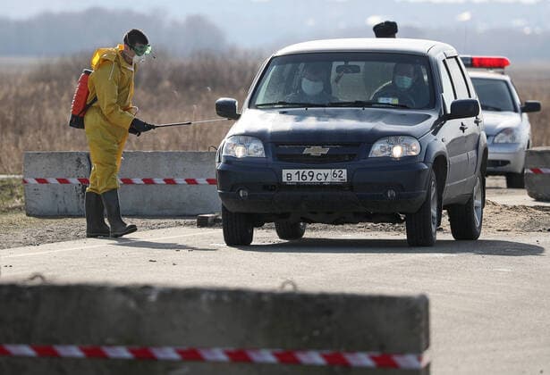 RYAZAN REGION, RUSSIA - APRIL 9, 2020: Disinfecting a vehicle at a checkpoint at an entrance to the village of Zaokskoye where several cases of the COVID-19 coronavirus infection were registered. The villages of Zaokskoye and Korostovo, Ryazan Region, have been put into lockdown from April 8 till April 22, 2020, to prevent the spread of the virus. Despite the novel coronavirus pandemic residents of the villages had been going to Moscow to sell dairy products, which, according to the local residents, led to the outbreak in the villages. Alexander Ryumin TASS  TS0D50A9