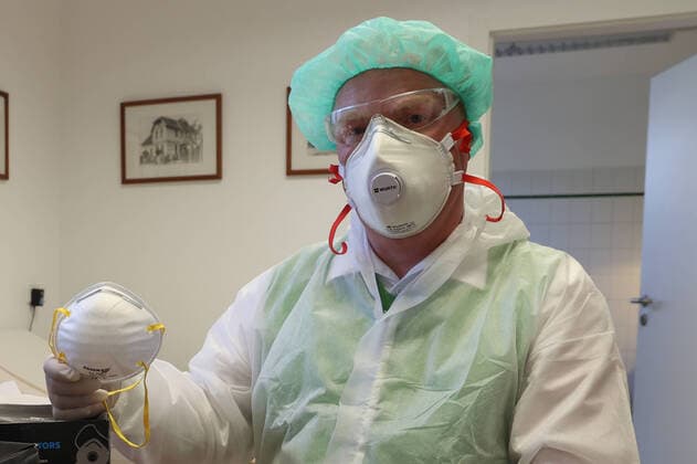 Coronavirus, mask deficiency in German medical practices, doctor, medical practice, family doctor, doctor with mouth protection, FFP2 mask, respiratory protection mask with filter, and disposable protective goggles, safety goggles,