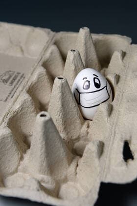Ostern während Corona ist geprägt von Abstandsregeln und Isolation - ein Hühnerei allein in einer Packung