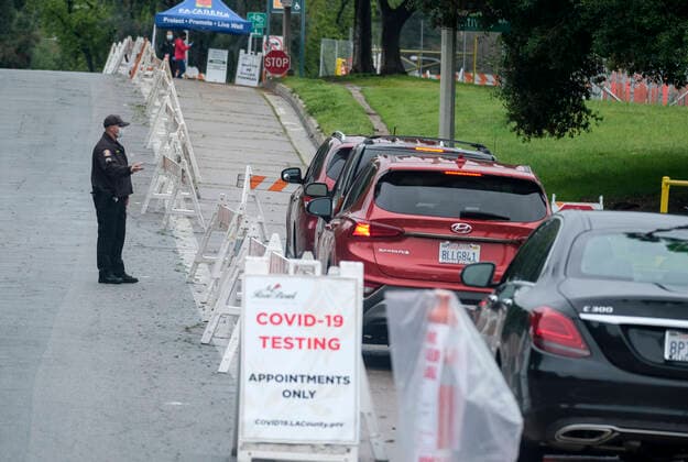 April 9, 2020, Los Angeles, California, U.S: A police officer wearing a mask directs motorists during a drive-through COVID-19 testing in a parking lot of the Rose Bowl in Pasadena, California on Thursday, April 9, 2020. Los Angeles U.S. - ZUMAc68_ 20200409_zaf_c68_016 Copyright: xRingoxChiux