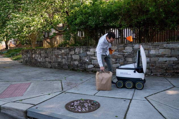 April 9, 2020: John Hodges retrieves his grocery order from a Starship Technologies robot in Washington, DC on Thursday, April 9, 2020. Broad Branch Market has closed their store due to COVID 19 and operating with phone-in orders, purchasing small items at the window and using Starship Technologies for robotic deliveries of food to the neighborhood. - ZUMAc206 20200409_zap_c206_008 Copyright: xKenxCedenox