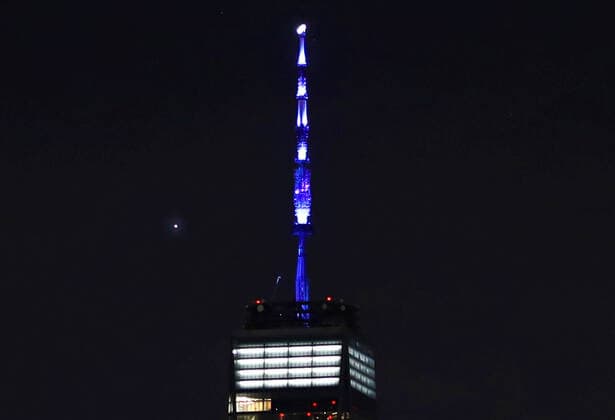 Planet Venus moves behind One World Trade Center while its spire is lit in in blue in New York City on Thursday, April 9, 2020. Over 150 buildings all over the country lit up blue tonight at 8pm local time in solidarity with the hospital workers and first responders fighting COVID-19.  NYP20200409111 JOHNxANGELILLO