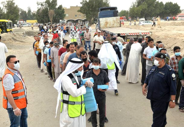 (200409) -- FARWANIYA GOVERNORATE (KUWAIT), April 9, 2020 (Xinhua) -- Residents in the area of Jleeb Al-Shuyoukh queue up to receive food in Farwaniya Governorate, Kuwait, on April 9, 2020. Kuwaiti government distributed on Thursday food baskets to residents of areas of Mahboula and Jleeb Al-Shuyoukh which are under lockdown to curb the spread of COVID-19. Kuwait reported on Thursday 55 new COVID-19 cases, bringing the total number in the country to 910, the health ministry said in a statement. (Photo by Asad Xinhua) KUWAIT-FARWANIYA GOVERNORATE-COVID-19-FOOD DISTRIBUTION 