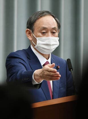 New coronavirus Japanese Chief Cabinet Secretary Yoshihide Suga holds a press conference in Tokyo on April 10, 2020, due to the coronavirus pandemic. 