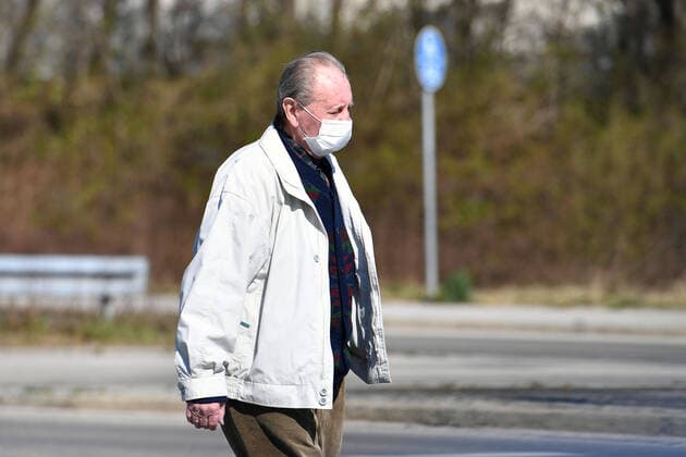 Public life in times of the Coronavirus Pandemic on 05 04 2020 in Munich An old man walks with face mask, face mask, mouth guard over a road, exit restrictions, contact ban
