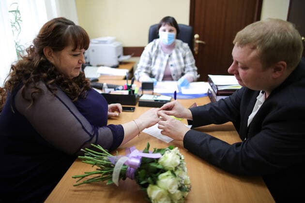 MOSCOW, RUSSIA - APRIL 10, 2020: Newlyweds exchange rings during a marriage registration at the Tagansky registry office. Since March 27, 2020, people can submit applications for a marriage registration in Moscow only by phone or a public services portal, and the Moscow registry offices and wedding palaces do not hold ceremonies with guests. Sergei Bobylev TASS  TS0D5370