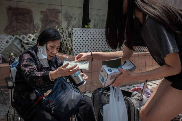 April 10, 2020, Hong Kong, China: An elderly homeless woman receives a surgical mask from a volunteer as a preventive measure against the spread of Coronavirus..As the coronavirus pandemic worsens, thousands of Hong Kong residents who live in cramped coffin homes or homeless situation are struggling to adjust to their new reality. Coronavirus cases in Hong Kong are close to the 1,000 mark. Hong Kong China - ZUMAs197 20200410_zaa_s197_021 Copyright: xSOPAxImagesx