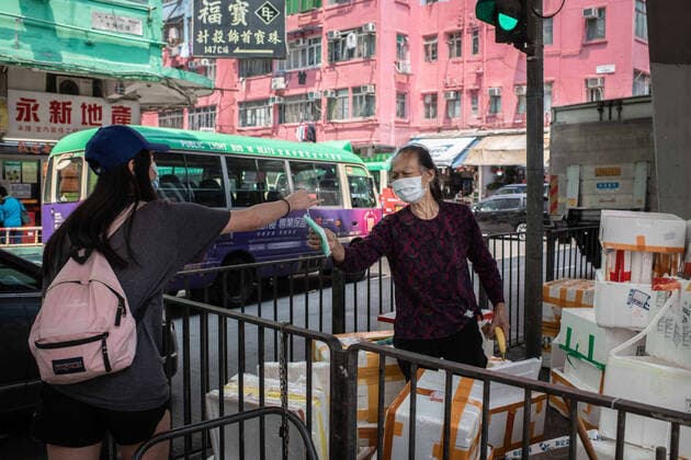 April 10, 2020, Hong Kong, China: A homeless man receives a surgical mask from a volunteer as a preventive measure against the spread of Coronavirus..As the coronavirus pandemic worsens, thousands of Hong Kong residents who live in cramped coffin homes or homeless situation are struggling to adjust to their new reality. Coronavirus cases in Hong Kong are close to the 1,000 mark. Hong Kong China - ZUMAs197 20200410_zaa_s197_030 Copyright: xSOPAxImagesx