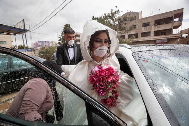 (200410) -- BETHLEHEM, April 10, 2020 (Xinhua) -- Palestinian groom, Ishaq Musleh, and his bride, Shima al-Titi, leave the beauty salon in the Palestinian Deheisheh refugee camp near the West Bank city of Bethlehem, on April 10, 2020. Wearing masks and gloves as preventive measures, the couple celebrated their wedding during the COVID-19 outbreak. (Photo by Luay Sababa Xinhua) MIDEAST-BETHLEHEM-COVID-19-WEDDING 