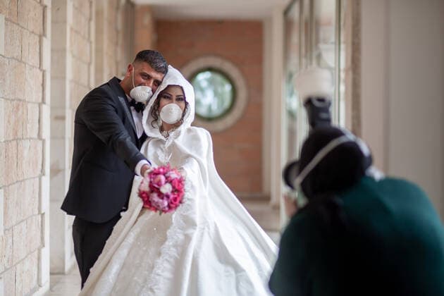 (200410) -- BETHLEHEM, April 10, 2020 (Xinhua) -- A Palestinian photographer takes pictures for the groom, Ishaq Musleh, and his bride, Shima al-Titi, in the Palestinian Deheisheh refugee camp near the West Bank city of Bethlehem, on April 10, 2020. Wearing masks and gloves as preventive measures, the couple celebrated their wedding during the COVID-19 outbreak. (Photo by Luay Sababa Xinhua) MIDEAST-BETHLEHEM-COVID-19-WEDDING 