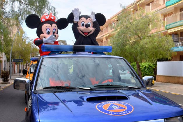 April 10, 2020, Vendrell, Spain: Civil Protection Volunteers from El Vendrell dressed as Mickey and Minnie Mouse greet people who are confined in their houses during the coronavirus crisis..Volunteers from Civil Protection of El Vendrell, two of them disguised as Disney characters, Mickey Mouse and Minnie Mouse have toured the streets of the city to cheer up the neighbours and the children who are in their homes, serving the confinement due the Covid-19 health crisis. Vendrell Spain - ZUMAs197 20200410_zaa_s197_049 Copyright: xRamonxCostax