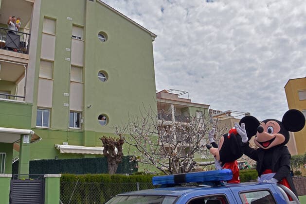 April 10, 2020, Vendrell, Spain: Civil Protection Volunteers from El Vendrell dressed as Mickey and Minnie Mouse greet people who are confined in their houses during the coronavirus crisis..Volunteers from Civil Protection of El Vendrell, two of them disguised as Disney characters, Mickey Mouse and Minnie Mouse have toured the streets of the city to cheer up the neighbours and the children who are in their homes, serving the confinement due the Covid-19 health crisis. Vendrell Spain - ZUMAs197 20200410_zaa_s197_050 Copyright: xRamonxCostax
