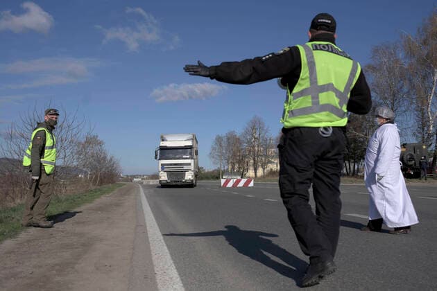 ZOLOCHIV, UKRAINE - APRIL 10, 2020 - A National Guard serviceman, a police officer and a healthcare worker are on duty at a roadblock set up on the border with Ternopil Region during the COVID-19 outbreak, Zolochiv, Lviv Region, western Ukraine. Roadblock in Zolochiv  Copyright: xMARKIIANxLYSEIKOx