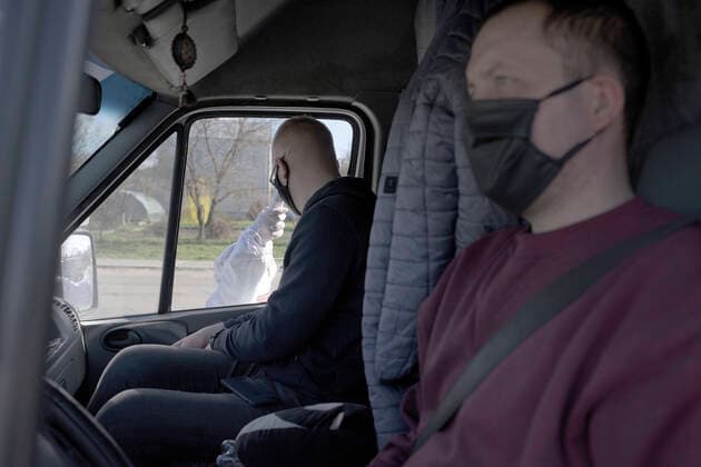 ZOLOCHIV, UKRAINE - APRIL 10, 2020 - A healthcare worker measures the body temperature of a passenger at a roadblock set up on the border with Ternopil Region during the COVID-19 outbreak, Zolochiv, Lviv Region, western Ukraine. Roadblock in Zolochiv  Copyright: xMARKIIANxLYSEIKOx