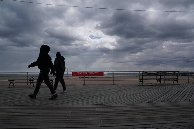 April 10, 2020, New York, NY, USA: People walk past a sign using social distancing on the boardwalk in the Coney Island section of the Borough of Brooklyn on April 10, 2020 in New York. New York USA - ZUMAb148 20200410_zap_b148_085 Copyright: xBryanxSmithx