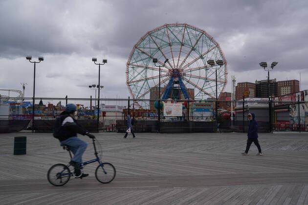 April 10, 2020, New York, NY, USA: People walk past the Wonder Wheel on a nearly deserted boardwalk in the Coney Island section of the Borough of Brooklyn on April 10, 2020 in New York. New York USA - ZUMAb148 20200410_zap_b148_135 Copyright: xBryanxSmithx