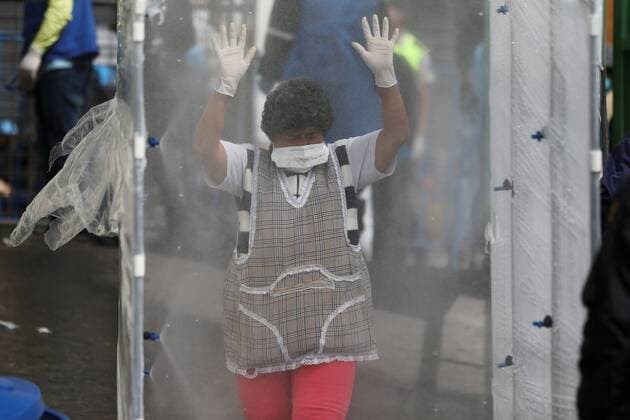 A woman with a facial mask enters through a disinfection tunnel in the San Roque market, one of the largest in Quito, Ecuador, 10 April 2020. Quito citizens buy there the ingredients of the famous Fanesca, the traditional stew of Easter in Ecuador, which is usually served on Good Friday. Fanesca, the Ecuadorian dish on Good Friday, stays at home due to COVID-19 !ACHTUNG: NUR REDAKTIONELLE NUTZUNG!  Copyright: xJosexJacomex AME1813 20200411-637221600172326275