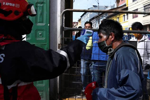 A firefighter takes a man s temperature in the San Roque market, one of the largest in Quito, Ecuador, 10 April 2020. Quito citizens buy there the ingredients of the famous Fanesca, the traditional stew of Easter in Ecuador, which is usually served on Good Friday. Fanesca, the Ecuadorian dish on Good Friday, stays at home due to COVID-19 !ACHTUNG: NUR REDAKTIONELLE NUTZUNG!  Copyright: xJosexJacomex AME1806 20200411-637221600791314935